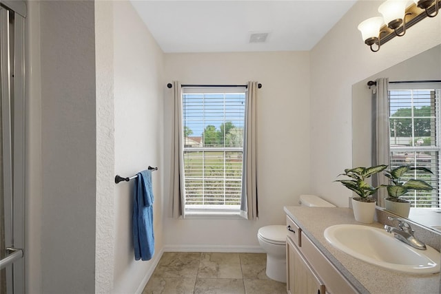 bathroom featuring plenty of natural light, toilet, baseboards, and vanity