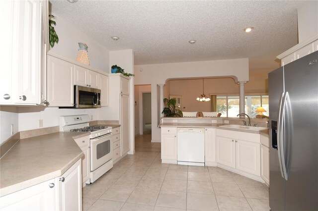 2120 Willow Grove Way, The Villages, FL 32162 - kitchen with appliances with stainless steel finishes, a sink, ornate columns, a textured ceiling, and a chandelier