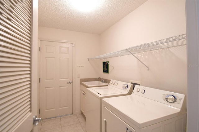 2120 Willow Grove Way, The Villages, FL 32162 - laundry room with cabinet space, washing machine and dryer, a textured ceiling, and light tile patterned flooring