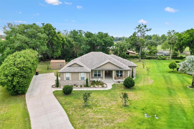 10465 SE 41st Ter, Belleview, FL 34420 - ranch-style house featuring covered porch, driveway, a front yard, stone siding, and stucco siding