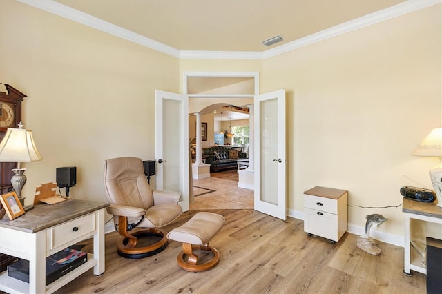 10465 SE 41st Ter, Belleview, FL 34420 - living area featuring arched walkways, ornamental molding, light wood-style floors, and baseboards
