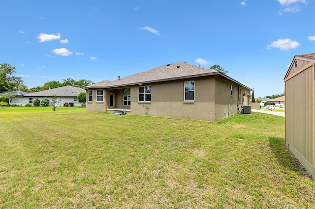 10465 SE 41st Ter, Belleview, FL 34420 - back of property with stucco siding, central air condition unit, and a yard