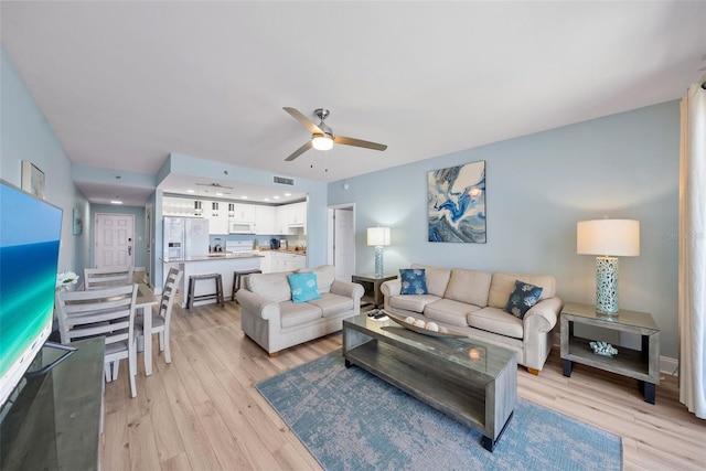 living room with light wood finished floors and a ceiling fan