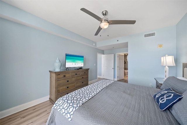 bedroom with wood finished floors, baseboards, ceiling fan, and ensuite bathroom