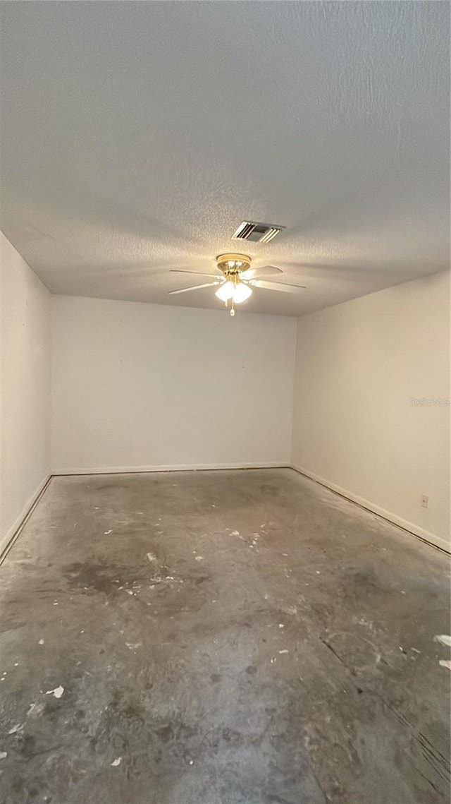 2421 Centennial Blvd, Leesburg, FL 34748 - spare room featuring unfinished concrete flooring, baseboards, a textured ceiling, and a ceiling fan