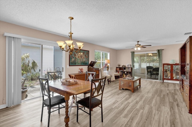 8932 SE 168th Sedgwick Pl, The Villages, FL 32162 - dining space featuring a textured ceiling, light wood finished floors, a chandelier, and ceiling fan