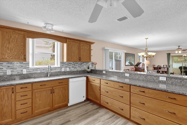 8932 SE 168th Sedgwick Pl, The Villages, FL 32162 - kitchen with dishwasher, ceiling fan, a sink, a textured ceiling, and light stone countertops