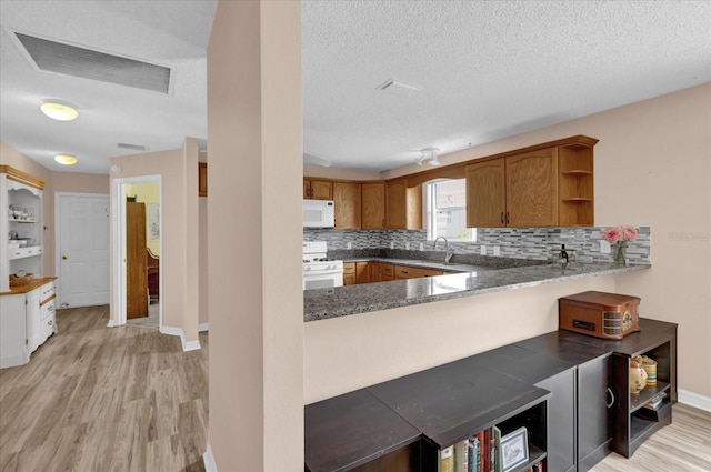 8932 SE 168th Sedgwick Pl, The Villages, FL 32162 - kitchen with white appliances, open shelves, light wood-style flooring, a sink, and decorative backsplash