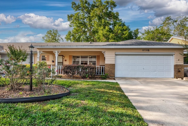 ranch-style home featuring an attached garage, concrete driveway, covered porch, a front yard, and brick siding