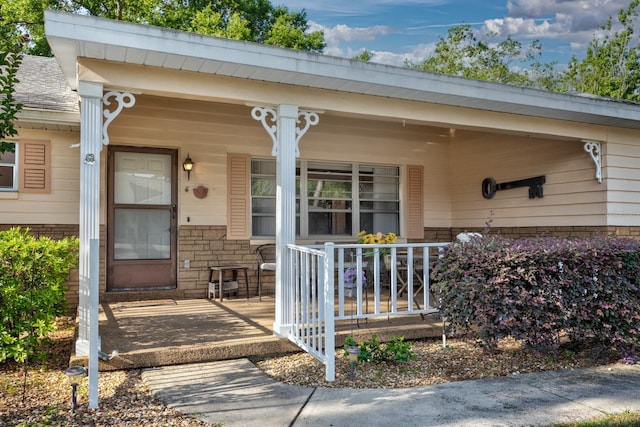 entrance to property with a porch and stone siding