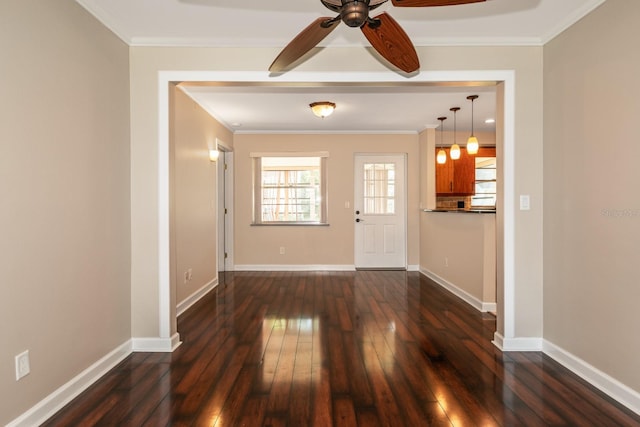 unfurnished living room featuring dark wood finished floors, a ceiling fan, baseboards, and ornamental molding