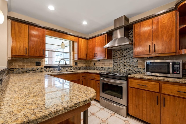 kitchen featuring stainless steel appliances, a sink, wall chimney range hood, open shelves, and brown cabinetry