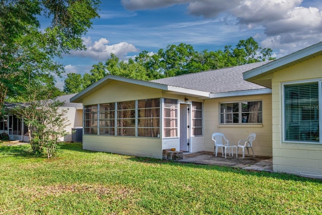 8738 SW 95th Ln Unit B, Ocala, FL 34481 - back of property with a sunroom, a yard, and a shingled roof