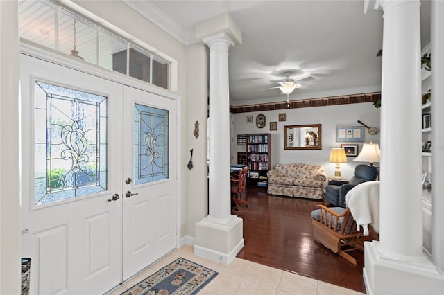 entryway featuring ornate columns, plenty of natural light, light tile patterned flooring, crown molding, and ceiling fan