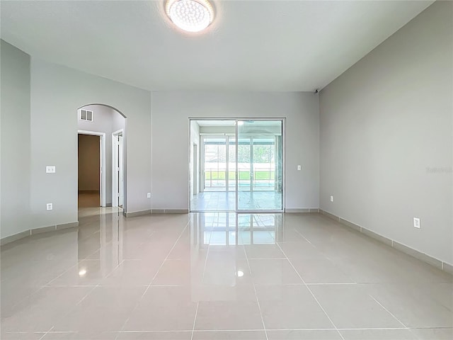 3731 Peaceful Valley Dr, Clermont, FL 34711 - spare room featuring arched walkways and light tile patterned flooring