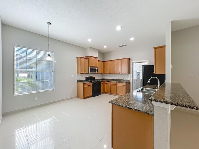 3731 Peaceful Valley Dr, Clermont, FL 34711 - kitchen with appliances with stainless steel finishes, dark stone countertops, a peninsula, hanging light fixtures, and brown cabinetry