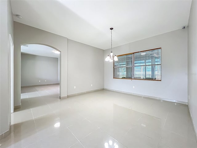 3731 Peaceful Valley Dr, Clermont, FL 34711 - unfurnished room with arched walkways, a smoke detector, tile patterned floors, and a chandelier