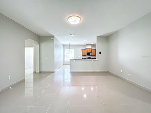 3731 Peaceful Valley Dr, Clermont, FL 34711 - unfurnished living room featuring light tile patterned floors and arched walkways