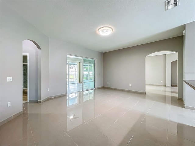 3731 Peaceful Valley Dr, Clermont, FL 34711 - unfurnished room with arched walkways and light tile patterned floors