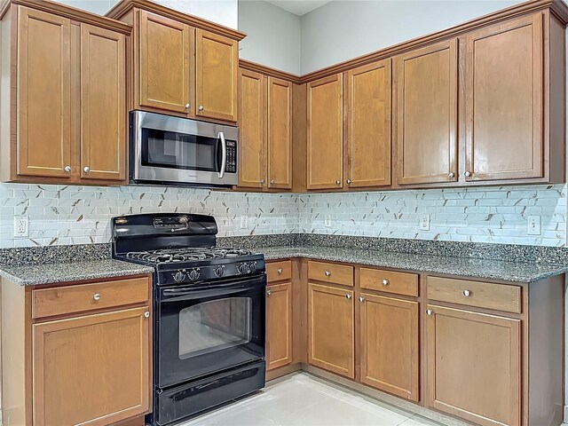 3731 Peaceful Valley Dr, Clermont, FL 34711 - kitchen with stainless steel microwave, gas stove, dark stone countertops, and backsplash