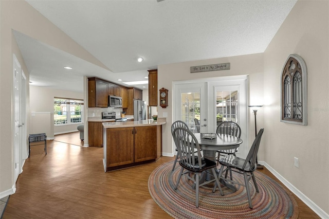 dining area featuring wood finished floors, lofted ceiling, baseboards, and recessed lighting