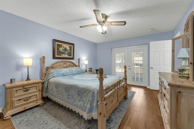 bedroom featuring french doors, access to outside, wood finished floors, a textured ceiling, and ceiling fan