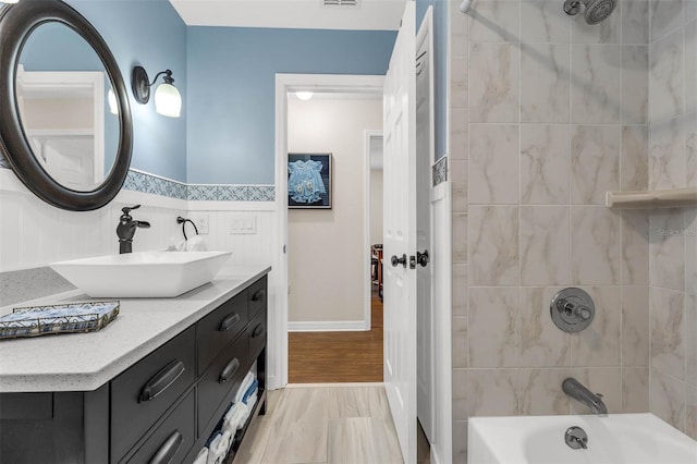 full bath featuring shower / bathtub combination, vanity, and tile walls