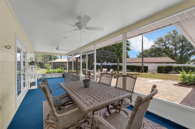 sunroom with ceiling fan and outdoor dining area