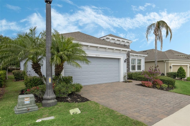 1027 Timbervale Trl, Clermont, FL 34715 - view of front of home featuring decorative driveway, an attached garage, a front lawn, and roof with shingles