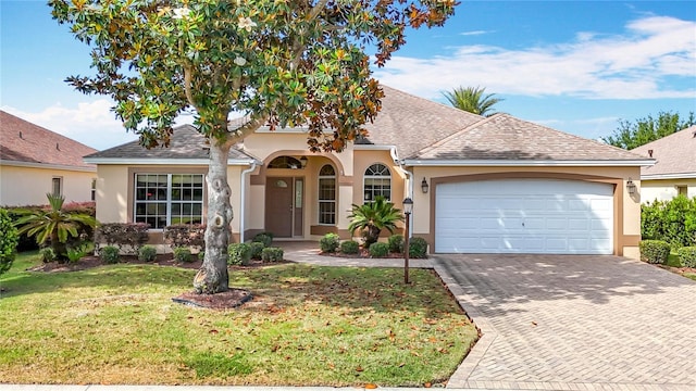 2202 Kershaw Rd, The Villages, FL 32162 - view of front facade featuring stucco siding, a front yard, decorative driveway, and an attached garage
