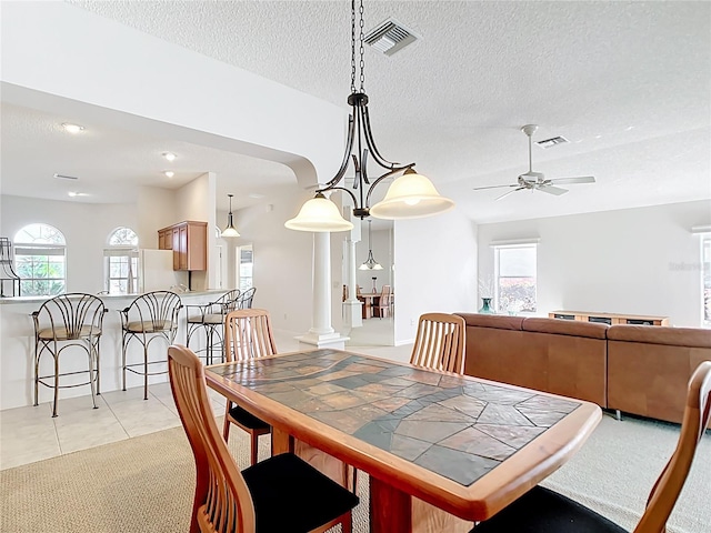 2202 Kershaw Rd, The Villages, FL 32162 - dining room with ceiling fan, a textured ceiling, light tile patterned floors, ornate columns, and light colored carpet