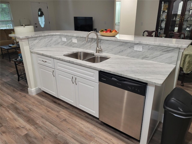 kitchen featuring dishwasher, a sink, wood finished floors, light stone counters, and white cabinets
