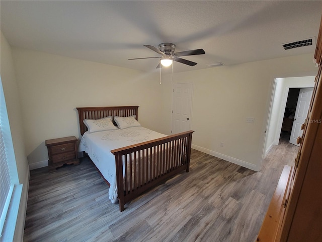 bedroom featuring wood finished floors, baseboards, and a ceiling fan