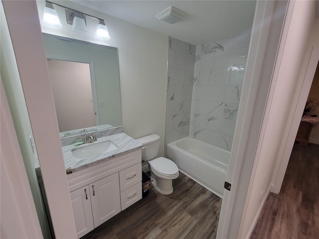 full bathroom featuring wood finished floors, toilet, vanity, and  shower combination