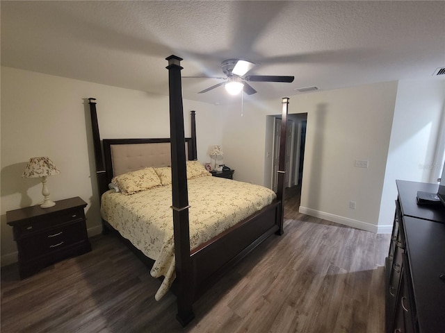 bedroom with dark wood-style flooring, baseboards, a textured ceiling, and a ceiling fan