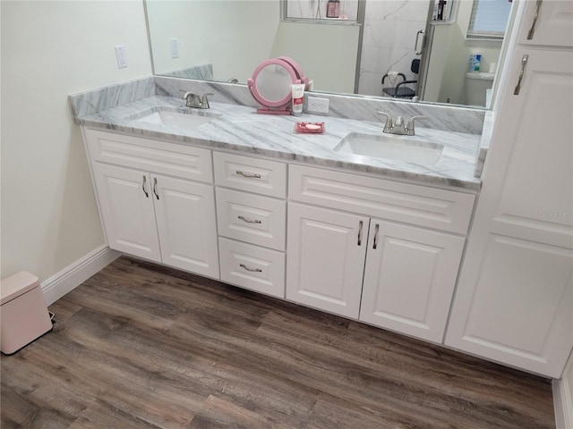full bathroom featuring double vanity, wood finished floors, and a shower stall