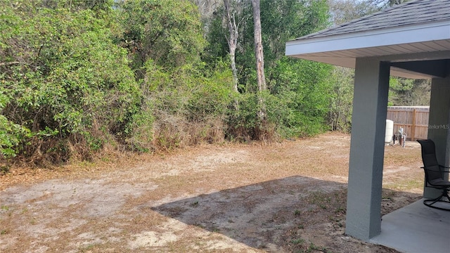 view of yard featuring fence and a wooded view