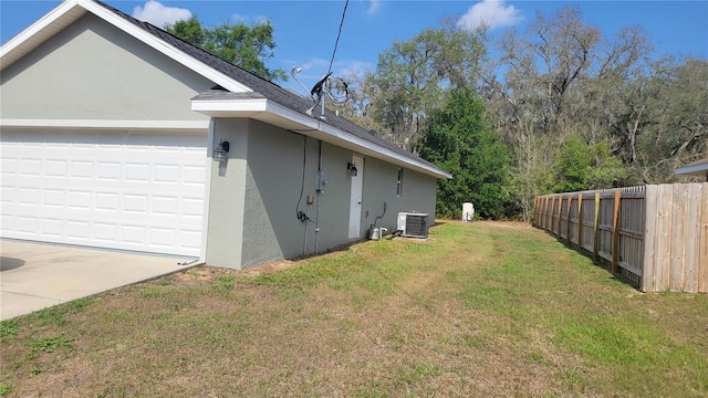 view of side of home with central air condition unit, stucco siding, and a garage