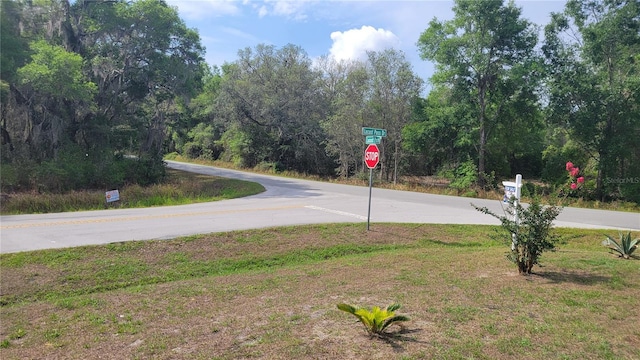 view of asphalt street with traffic signs