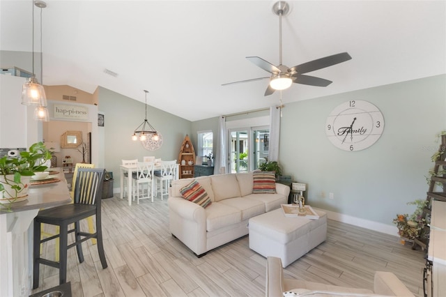 12401 Blue Heron Way, Leesburg, FL 34788 - living room featuring vaulted ceiling, a ceiling fan, light wood-style floors, a chandelier, and baseboards