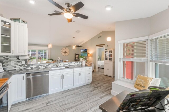12401 Blue Heron Way, Leesburg, FL 34788 - kitchen featuring stainless steel dishwasher, a sink, ceiling fan, a peninsula, and vaulted ceiling