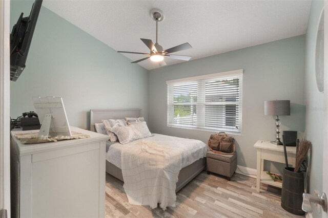 12401 Blue Heron Way, Leesburg, FL 34788 - bedroom featuring light wood finished floors, a ceiling fan, vaulted ceiling, and baseboards