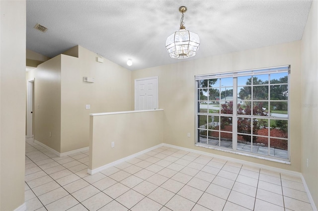 2304 Clementine Trl, Clermont, FL 34714 - spare room featuring a textured ceiling, tile patterned floors, a chandelier, and vaulted ceiling