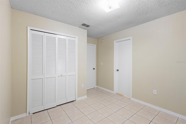 2304 Clementine Trl, Clermont, FL 34714 - unfurnished bedroom featuring a closet, a textured ceiling, and light tile patterned flooring