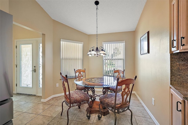 2096 Callaway Dr, The Villages, FL 32162 - dining space featuring a chandelier, light tile patterned floors, a textured ceiling, baseboards, and lofted ceiling
