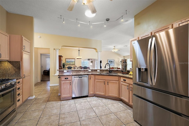 2096 Callaway Dr, The Villages, FL 32162 - kitchen featuring stainless steel appliances, a ceiling fan, decorative columns, a sink, and dark stone countertops