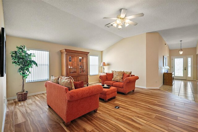 2096 Callaway Dr, The Villages, FL 32162 - living area featuring light wood-style flooring, lofted ceiling, ceiling fan, a textured ceiling, and baseboards