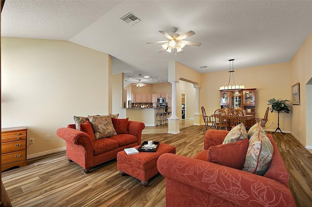 2096 Callaway Dr, The Villages, FL 32162 - living area featuring ornate columns, a ceiling fan, wood finished floors, baseboards, and vaulted ceiling