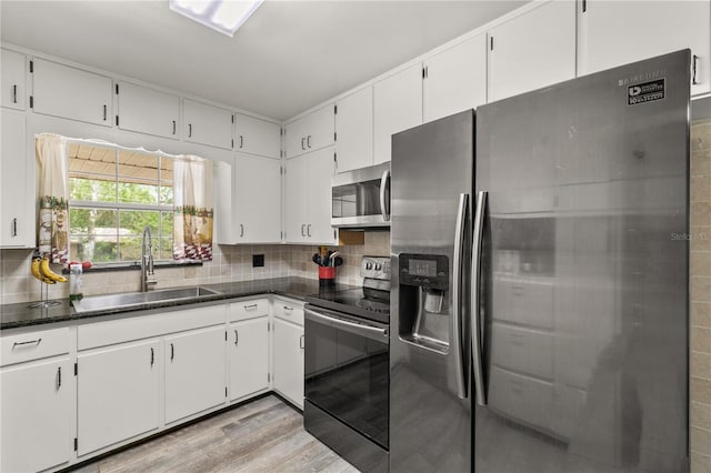 800 Jefferis Ct, Eustis, FL 32726 - kitchen featuring appliances with stainless steel finishes, a sink, decorative backsplash, and white cabinets