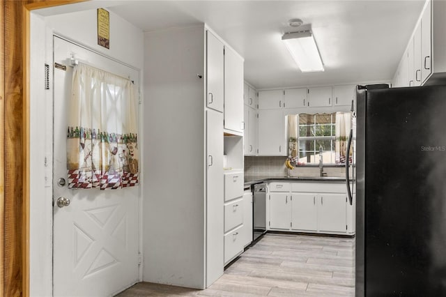 800 Jefferis Ct, Eustis, FL 32726 - kitchen with appliances with stainless steel finishes, a sink, light wood finished floors, backsplash, and dark countertops